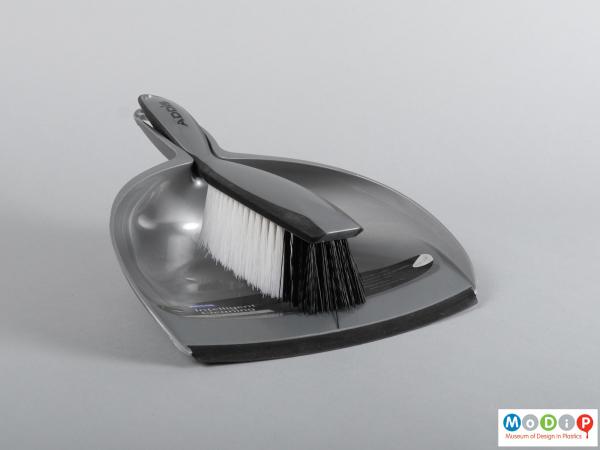 Front view of a dustpan and brush showing them clipped together.