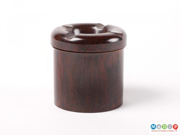 Side view of a small ink well showing the straight sides of the base and the indentations in the lid.