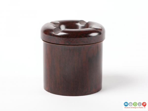 Side view of a small ink well showing the straight sides of the base and the indentations in the lid.