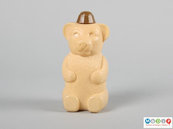 Front view of a bear shaped bottle showing the face and paws.