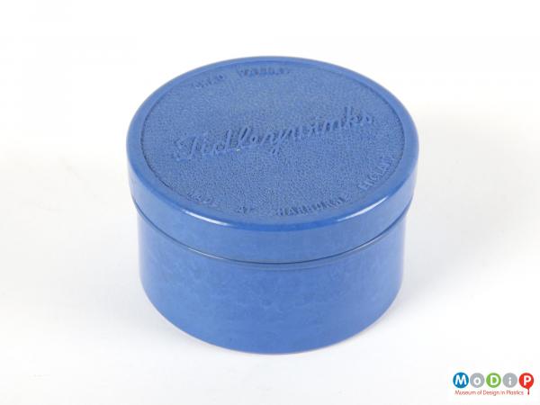 Side view of a set of tiddlywinks showing the container.