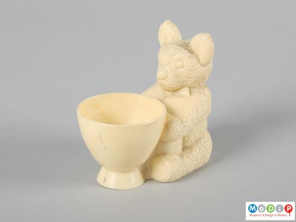 Side view of an egg cup showing the cup in front of the seated bear.