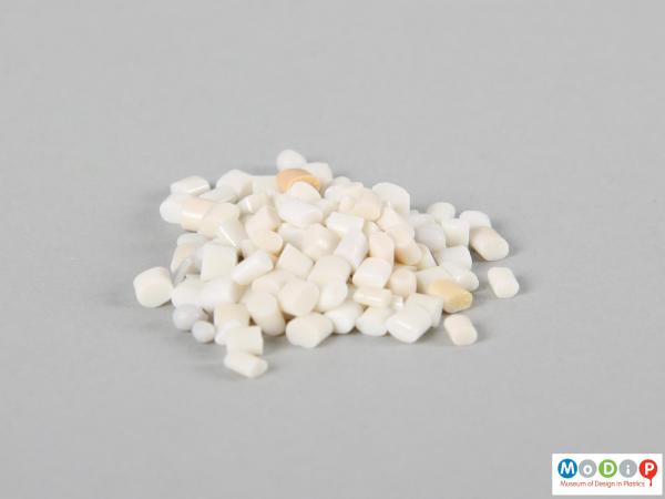 Side view of a sample of material showing the cream and white pellets.