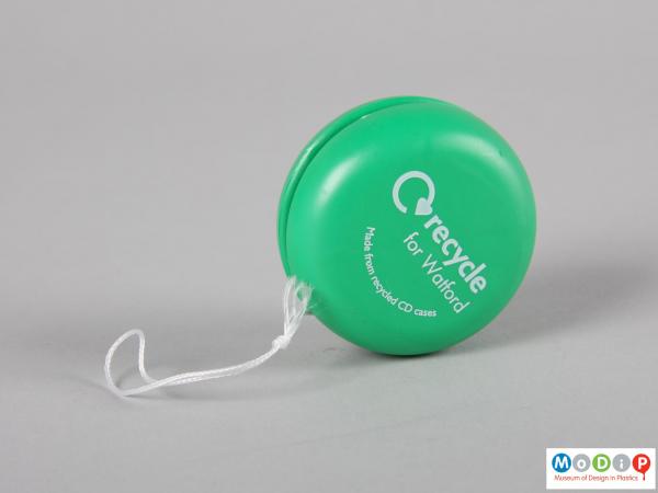 Side view of a yo-yo showing the string and printed inscription.