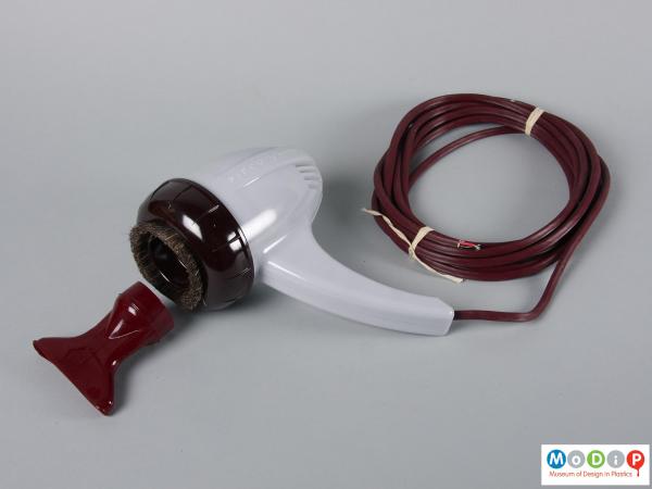 Side view of a hand held vacuum showing the cable and nozzle.