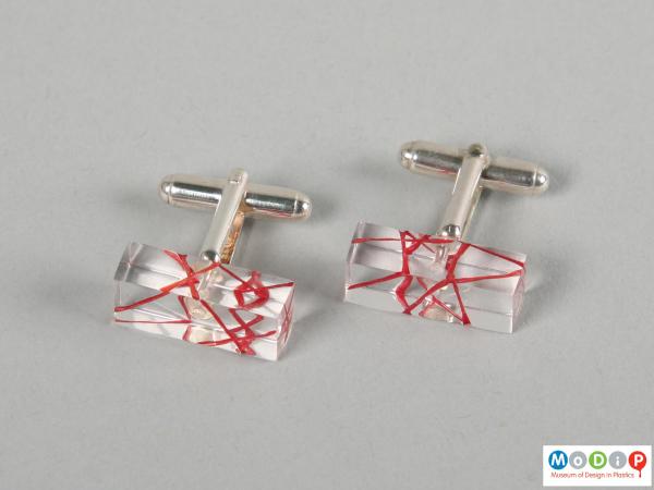 Side view of a pair of cuff links showing the clear material.