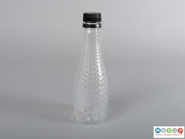 Side view of a bottle showing the clear cut glass style pattern.