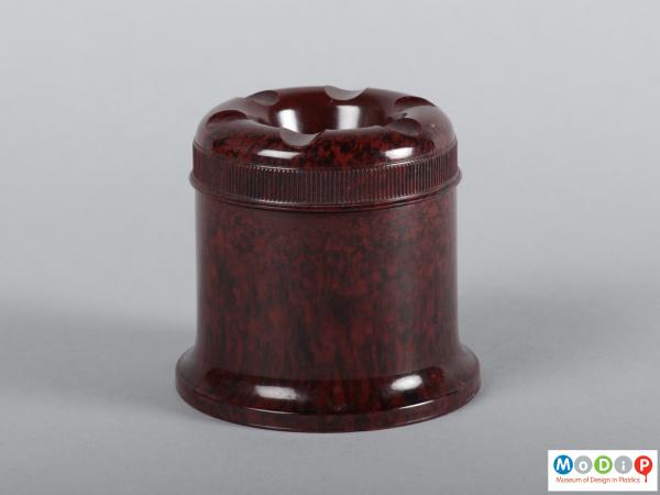 Side view of an ink well showing the stright sides of the base and the ribbed grip on the lid.