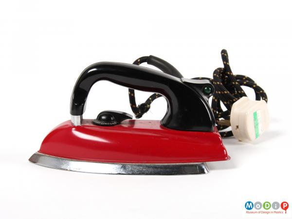 Side view of a Morphy Richards iron showing the red body and black curved handle.