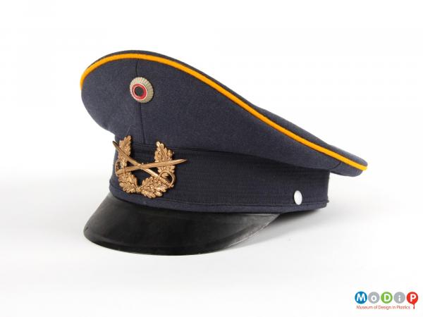 Front view of a hat showing the peak and badges.