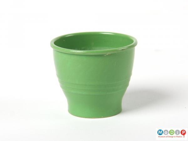 Side view of a green egg cup showing the small straight foot at the base.