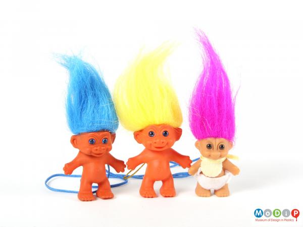 Front view of 3 trolls showing the long tapering hair.