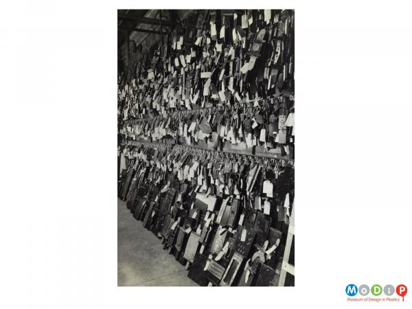 Scanned image showing a wall of hanging jigs and tools.