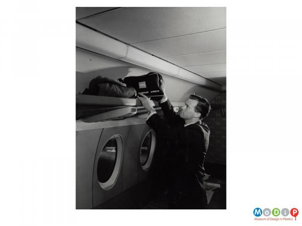 Scanned image showing a man inside an aeroplane.