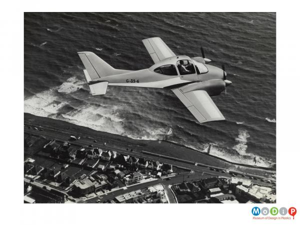 Scanned image showing a small plane in flight.