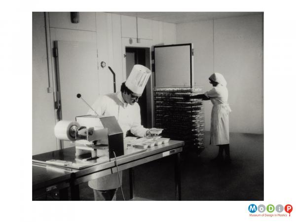 Scanned image showing ready meal trays in the process of being filled.