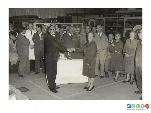 Scanned image showing a female employee receiving a gift.