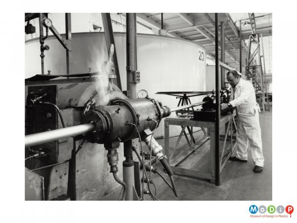 Scanned image showing a male worker at a cable extrusion facility.