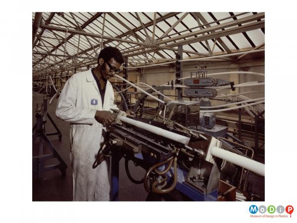 Scanned image showing a male employee testing a cable.