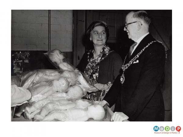 Scanned image showing a Mayoral party inspecting dolls.