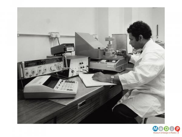 Scanned image showing a man sat at testing equipment.
