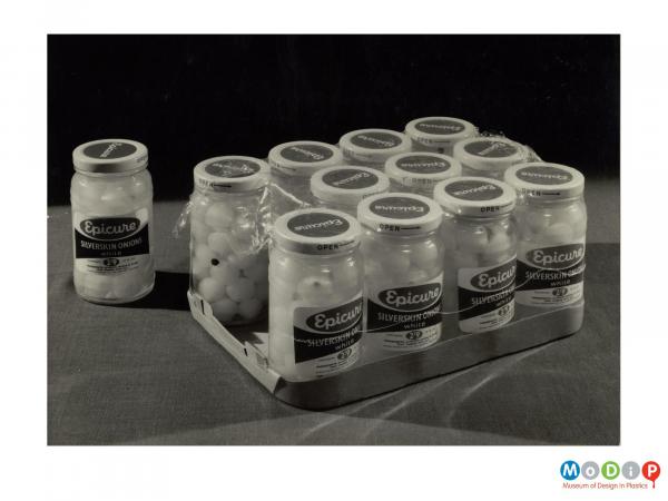 Scanned image showing jars of pickled onions shrink wrapped onto a cradboard tray.