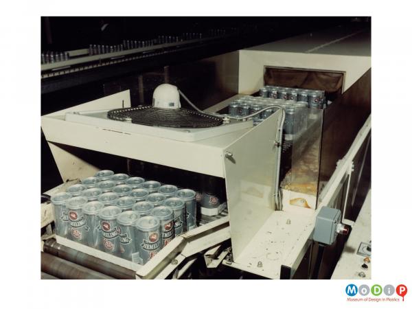 Scanned image showing beer cans on a packaging line.