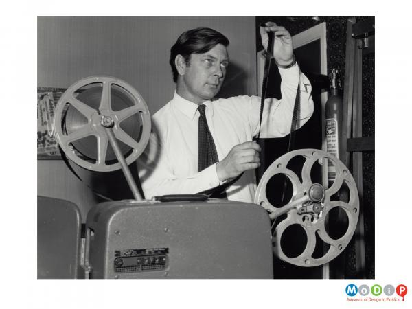 Scanned image showing a man looking at a projector film.