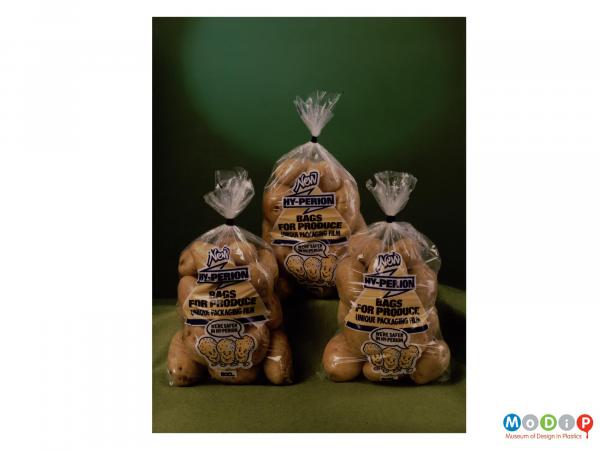 Scanned image showing three bags filled with potatoes.