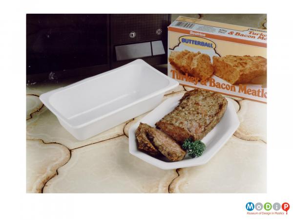 Scanned image showing a meatloaf box and microwavable container along with the meatloaf sitting in a serving dish.