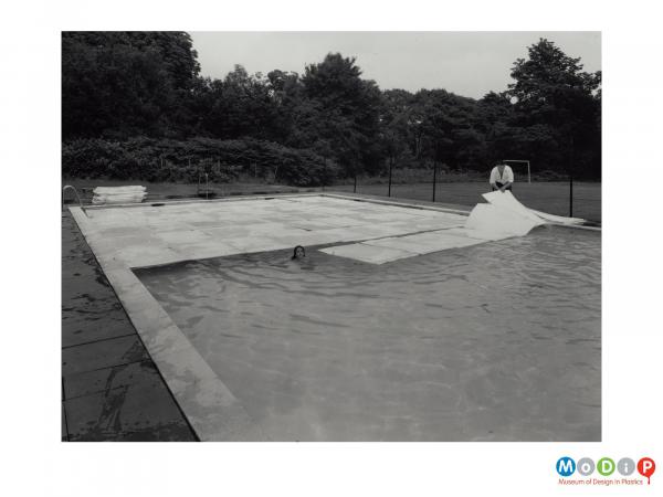 Scanned image showing a swimming pool half covered with Plastazote sheets.