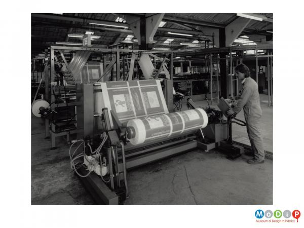 Scanned image showing a male employee working a machine.