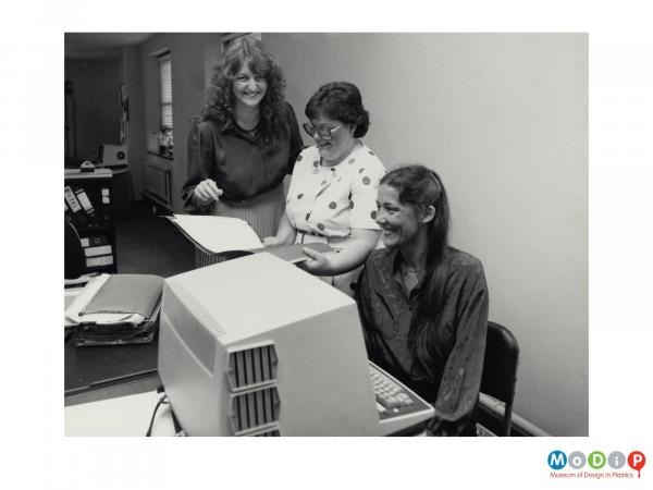 Scanned image showing 3 female employees in an office.