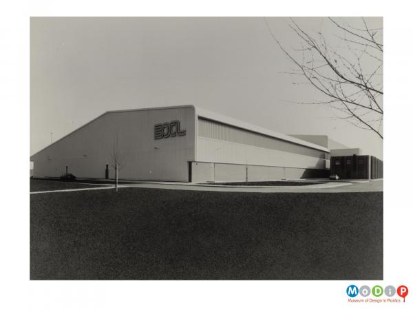 Scanned image showing an external view of a building with the lettering BXL on the side.