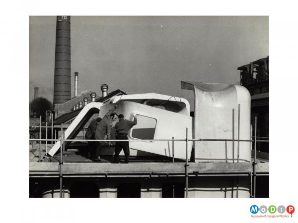 Scanned image showing a cabin cruiser being built.