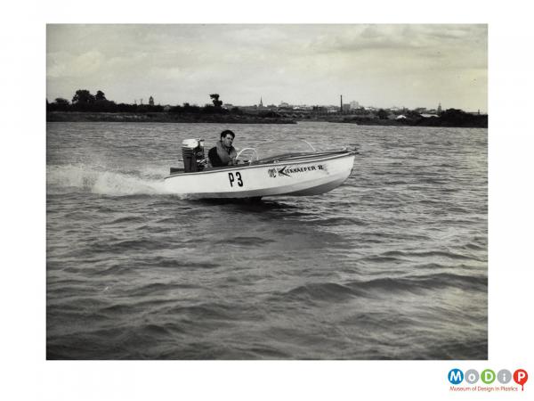 Scanned image showing small motor boat on the water.