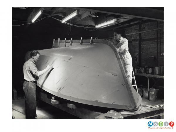 Scanned image showing a small boat being made.
