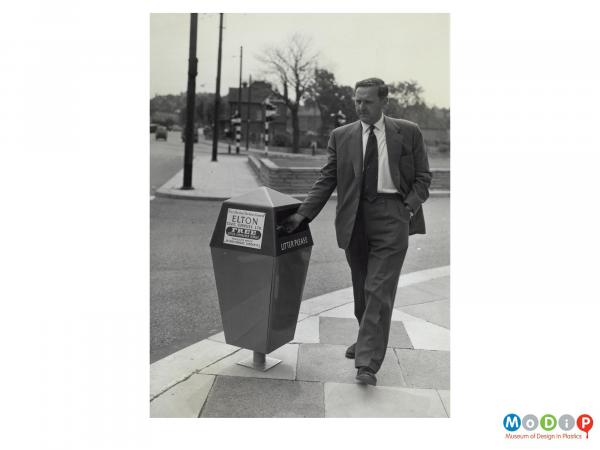 Scanned image showing a man using a bin.