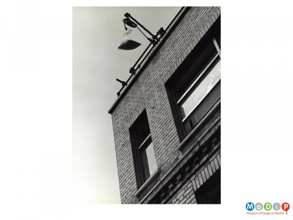 Scanned image showing a filled polythene bag held at the top of a building ready for a drop test.