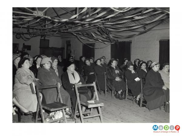 Scanned image showing a group of women seated in rows.