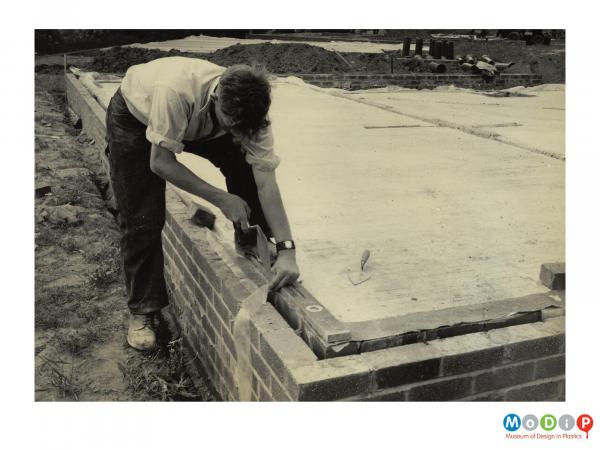 Scanned image showing a dampcourse being laid.