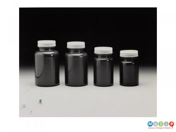 Scanned image showing 4 dark bottles of graduating size.