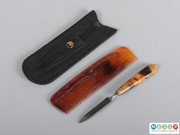 Side view of a comb and file set showing the pouch, comb and file.