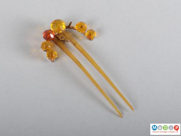 Top view of a hairpin showing the beaded top and two teeth.