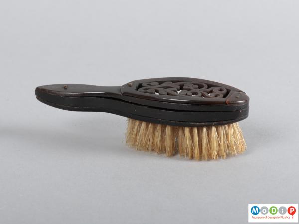 Side view of a brush and comb set showing the bristles and handle.