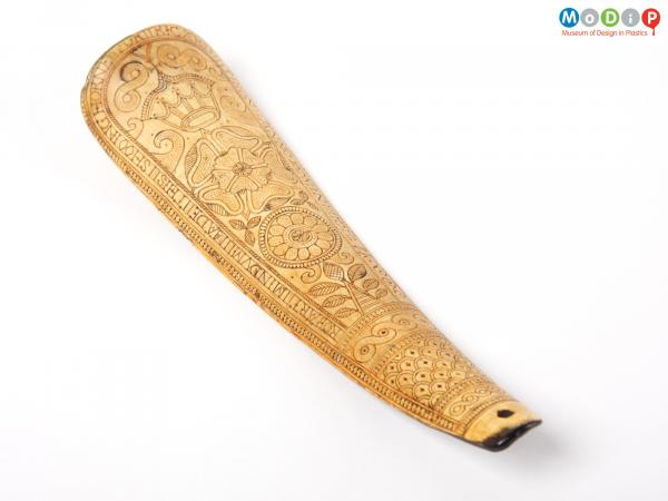 Front view of a shoe horn showing the elaborate engraving.