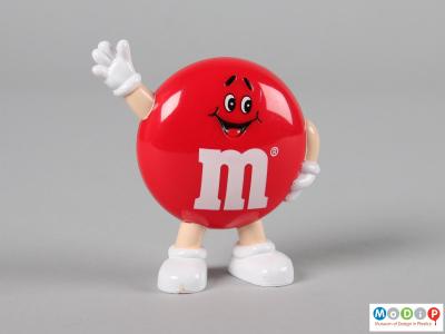 Front view of a brown M&M figure showing the smiling face and the limbs.