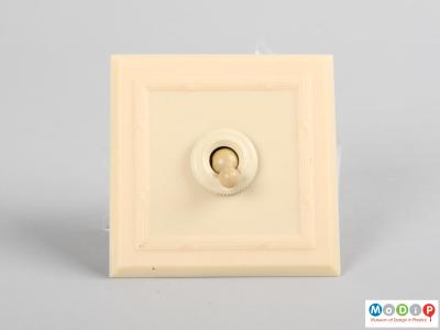 Front view of a light switch and surround showing the square bevelled edges.
