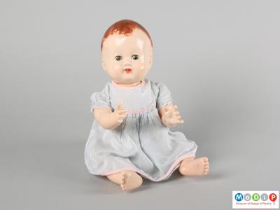 Front view of a Pedigree doll showing the doll in a seated position with arms foward and eyes open.