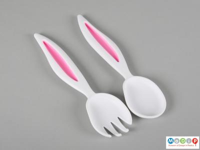 Front view of a pair of salad servers showing the pink detailing inside the ears.